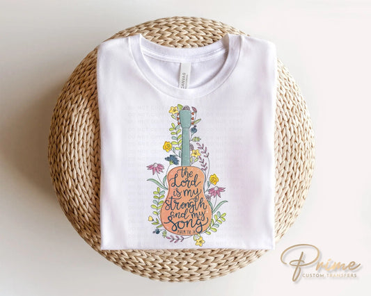 A cold peel direct to film transfer of a guitar with flowers, with the Bible verse, The Lord is My Strength and My Song, Psalm 118:14