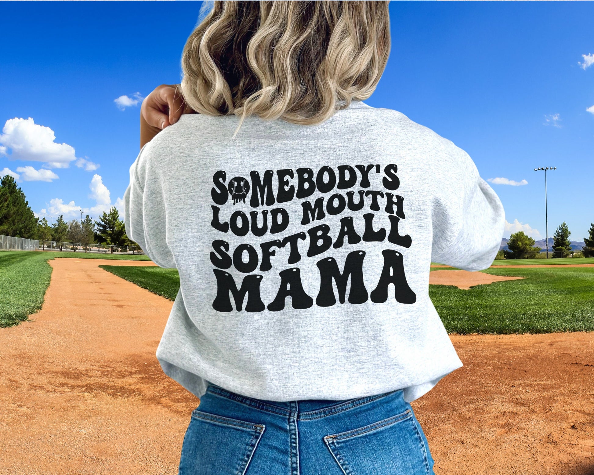 A direct to film transfer that says Somebody&#39;s Loud mouth Softball Mom. Back and front option. Front design is of baseball smiley face. The DTF transfer is a cold peel ready to press transfer.